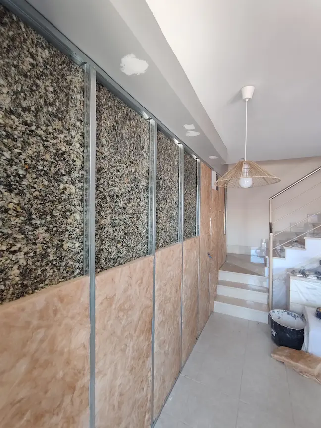 En DRUm somos especialistas en aislamientos en castellón, en la imagen vemos una pared a la que estamos colocando panel de piliuretano y lana de roca por encima